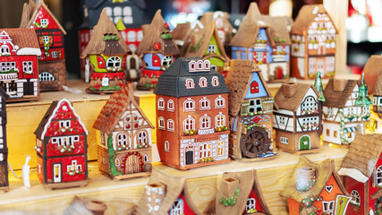 Old houses set stand on a shelf. Medieval European colorful houses made of ceramics. Souvenirs at the Christmas market. Old town street toys. - obrazy, fototapety, plakaty