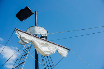 Ship mast background. Old retro wooden construction. Black flag ship. Yacht travel background....