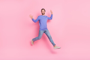 Full body photo of brunet funky young guy run wear blue pullover jeans sneakers isolated on pink background