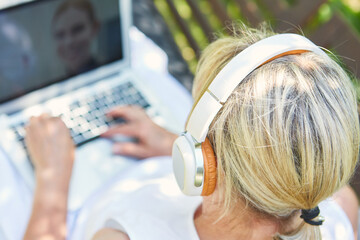 Freelancer Frau mit Kopfhörern am Laptop Computer