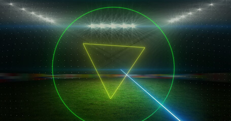 Image of rotating neon shapes and lights over floodlit sports field