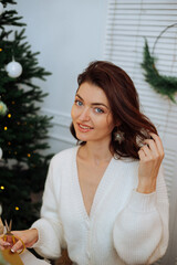 A beautiful girl is sitting at her desk and packing New Year's gifts. New Year's mood. Merry Christmas