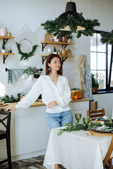  beautiful girl is smiling, standing in the kitchen in the New Year decorations. New Year's mood. Merry Christmas.