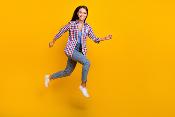 Fototapeta na wymiar Full length profile photo of cheerful sportive lady jump run shopping wear plaid shirt isolated yellow color background