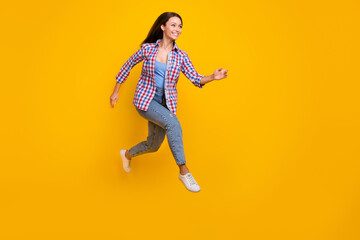 Fototapeta na wymiar Full length profile photo of energetic active cute lady jump run wear plaid shirt isolated yellow color background