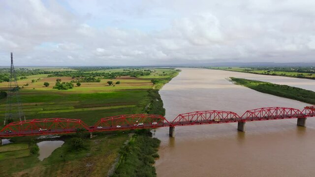 Bridge over the Cagayan River, Philippines, aerial view. Road bridge over a wide river. Cars ride on the bridge. Landscape, agricultural fields near the river.