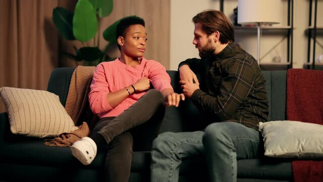 Happy interracial family have rest, talk at home, free time. Attractive young man talking with beautiful African American woman. High quality 4k footage