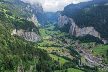 Plakat iconico valle suizo lleno de cascadas y cabañas de madera llamado Lauterbrunnen