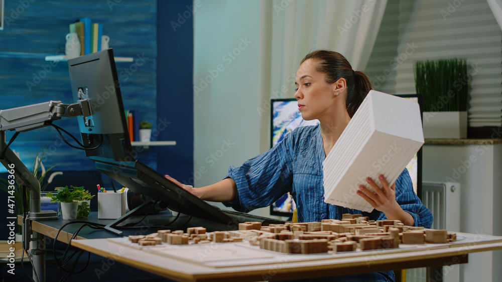 Poster Architect analyzing maquette for architectural development. Woman engineer using building model on table and touch screen computer for construction design. Architecture project.