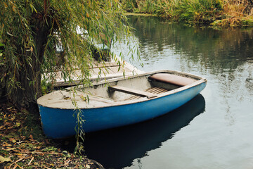 Light blue wooden boat on lake near pier