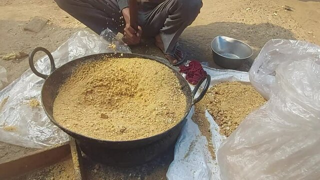 Man Hammering Sesame seeds Til Gul Mixed With Cashew Nut Kaju, Almond Badam, Peanut Moongfali To Make Fine Powder. Ingredient For Khasta Gur Ke Gajak Burfi Or Gazak Laddu On Makar Sankranti And Lohri