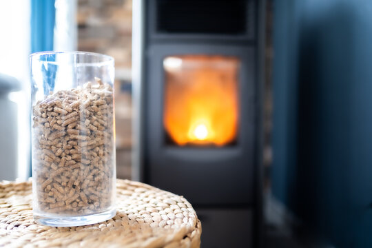 A Pot Of Pellets To Heat The Fireplace With A Wood Stove In The Background - Horizontal Photography