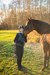 happy girl with a horse after riding lesson - obrazy, fototapety, plakaty