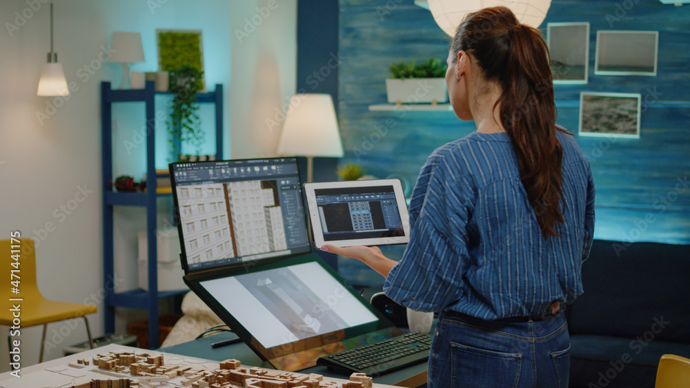 Poster professional engineer looking at building model on tablet and computer in workplace for architecture