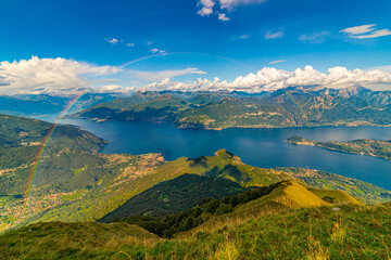 The panorama of Lake Como, photographed from Monte di Tremezzo, showing the Northern Grigna, the Southern Grigna, the Lecco branch, the town of Bellagio, the surrounding mountains, and a rainbow.