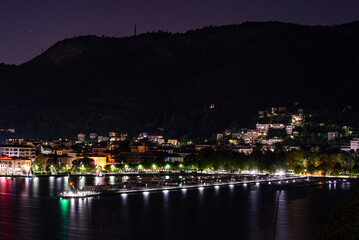 Fototapeta na wymiar Panorama of the lakefront of Como, and of the outer dam with the Life Electric monument, in a summer evening. 