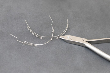 drawing up a multiloop ortho-arc on a gray background in a special tool. dentistry, beautiful smile