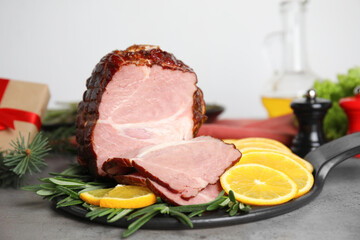 Delicious ham served with orange and rosemary on grey table. Christmas dinner