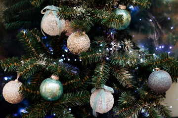Decorative balls, lights and garlands on the Christmas tree, holiday background. 