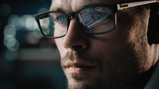 Close-up Portrait of Software Engineer Working on Computer, Line of Code Reflecting in Glasses. Developer Working on Innovative e-Commerce Application using Machine Learning, AI Algorithm, Big Data