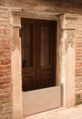 A metal barrier is installed on the doors of an old historic building to retain water during a flood