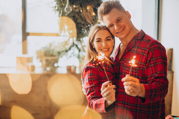 Young couple with bengal lights celebrating
