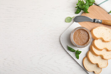 Delicious meat pate, fresh bread, knife and basil on white wooden table, flat lay. Space for text