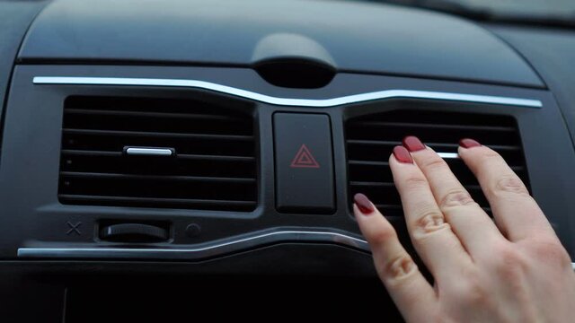 Car driver or passenger warming their hands in the car with the help of warm air
