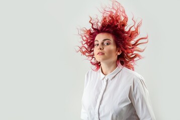 beautiful red-haired girl posing on a white background in a white shirt with emotions on her face