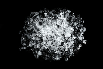 Heap of crushed ice on black table, top view