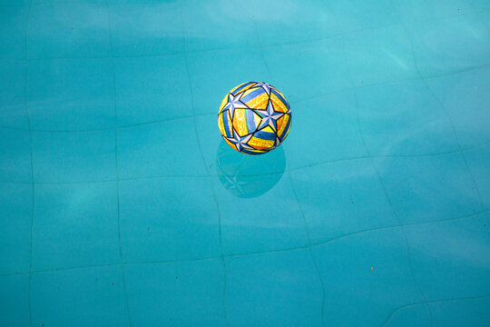 Colorful Ball With Print Floating In Water From The Pool