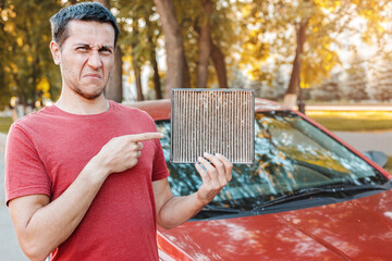Frustrated car driver with an allergy to dust collected in an old dirty ventilation filter....