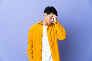 Young Chinese man isolated on purple background with headache