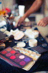 Close up various face cosmetic containers lay on table with mirror. Make up artist tools background