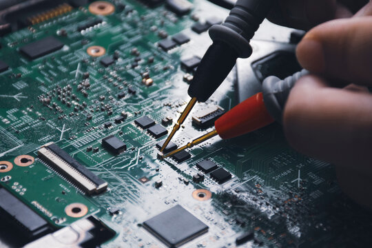 Technician Checking Laptop Circuit Board With Multimeter