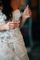 Female person in white dress hold glass of sparkling wine on weddings with copy space blurry background