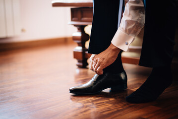 Close man tying shoe laces and prepare for formal event .The man wears shoes. To prepare for work, to the meeting or wedding.