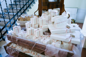 Beautiful many white wedding gift boxes set up on table for wedding celebrations at home indoors