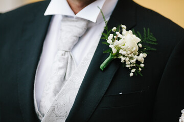 Close up stylish groom suit outfit with flower tuxedo and napkin on side. Groom accessories and style concept