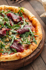 Gourmet appetizing pizza with dried horse meat and arugula