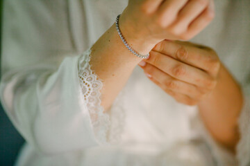 Obraz na płótnie Canvas Female woman touch shiny stylish bracelet on right hand close up. Bridal accessories on wedding day