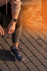 Fit woman checking smart watch wearable technology, sport smartwatch on fitness run walk outside. Top view from above with running shoes in street.