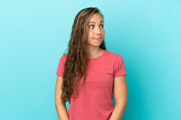 Young caucasian woman isolated on blue background making doubts gesture looking side