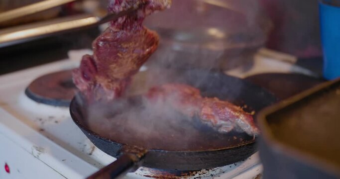 Hand Turns Spicy Smoking Meat With Clutching Tong in an Old Countryside Kitchen, Handheld Medium Shot
