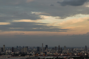Naklejka na ściany i meble Bangkok, Thailand - Sep 12, 2021 : Gorgeous panorama scenic of the sunrise or sunset with cloud on the orange and blue sky over large metropolitan city in Bangkok. Copy space, No focus, specifically.