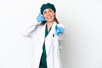 Surgeon caucasian woman in green uniform isolated on white background making phone gesture and pointing front