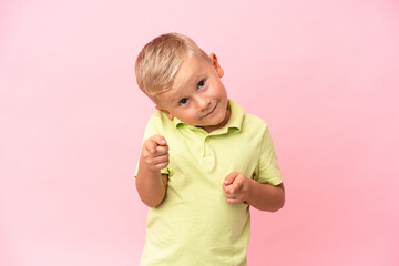 Little Russian boy isolated on pink background points finger at you with a confident expression