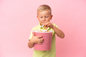 Little Russian boy eating popcorns in a big bowl over isolated background