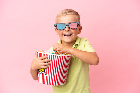 Little Russian boy eating popcorns in a big bowl over isolated background