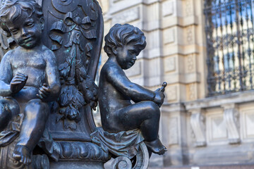 Fototapeta na wymiar Bronze floor lamps are decorated with putti figures that represent various crafts in front of the A. L. Stieglitz Academy in St. Petersburg, Russia